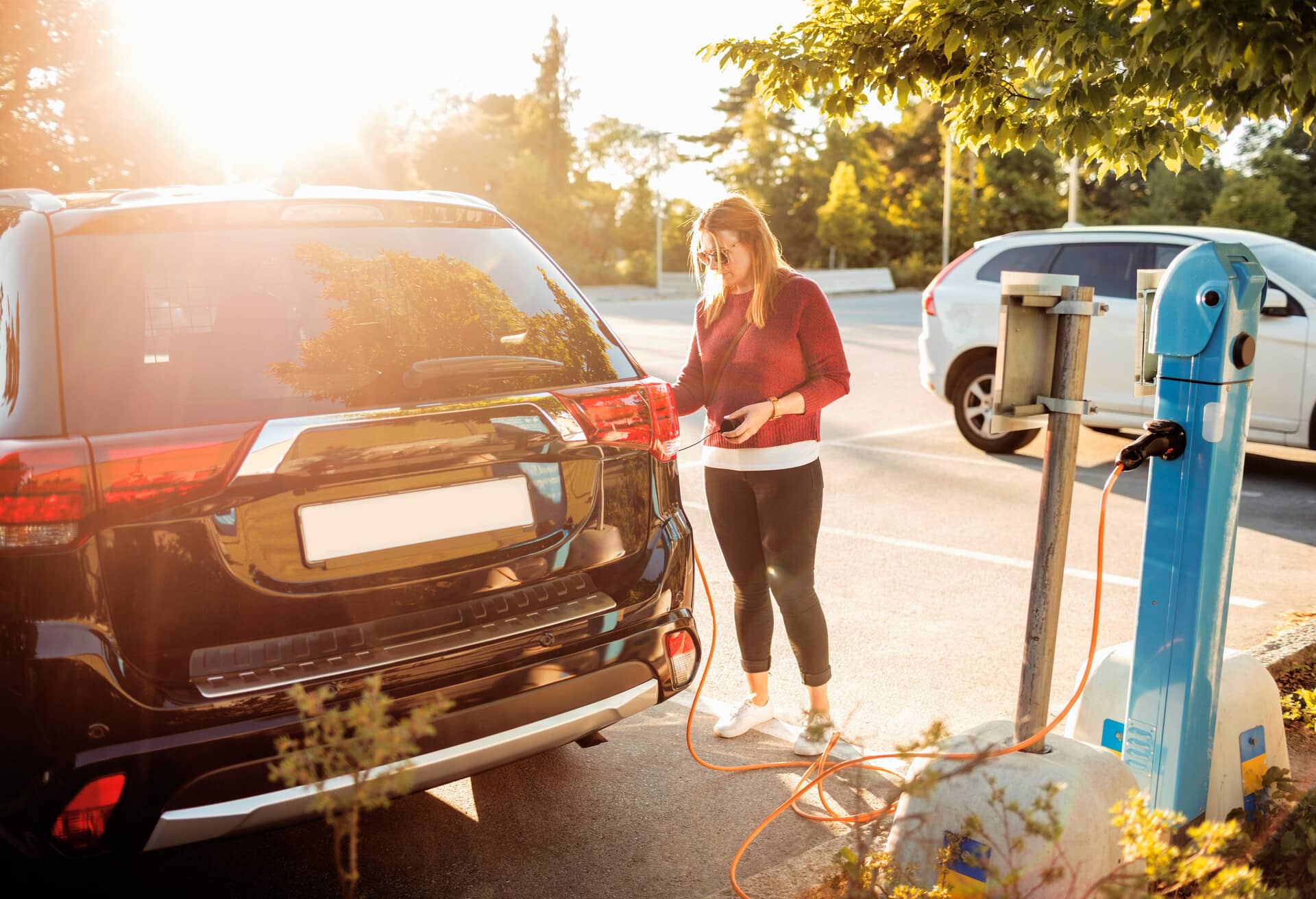 O fată încarcă o mașină electrică