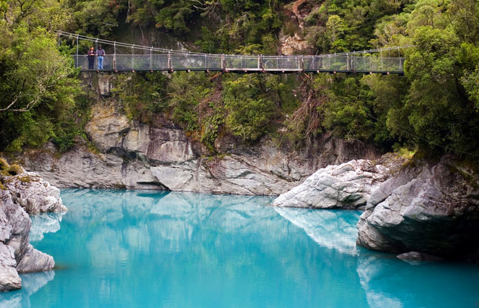 O strângere dramatică de mână între un albastru azur și un verde smarald – asta-i cea mai fidelă definiție a țărmului din Hokitika Gorge