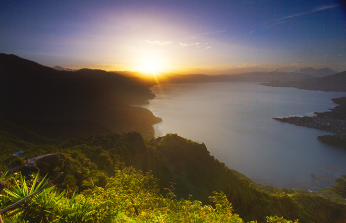 Wake up to the rays shining over Lake Atitlan in Guatemala