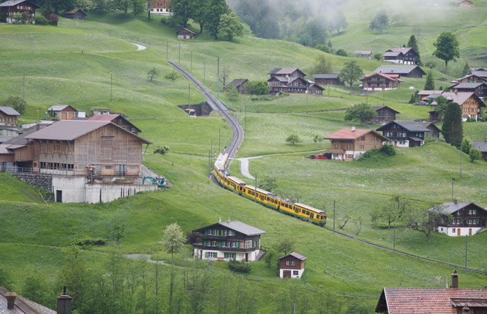 Încearcă să ajungi în vârful dealului în timp ce trenul se pierde la vale în urma ta, în peisajul netulburat de sat alpin - Griendelwald