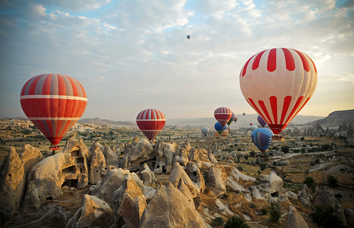 Baloanele colorate cu aer cald se înalță deasupra Cappadociei de parcă își iau o vacanță de la viața pe acest Pământ