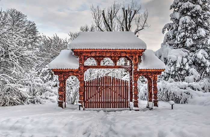 Când ninsoarea se așterne binișor peste-o poartă maramureșană, sculptată în lemn