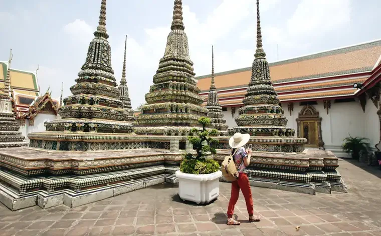 Young woman tourist taking picture at temple sightseeing in Bagnkok Thailand during traveling