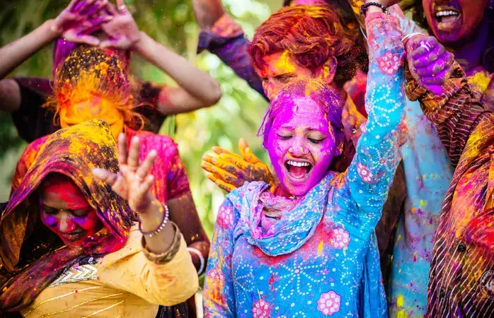 Indian Friends Dancing Covered on Holi colorful powder in India